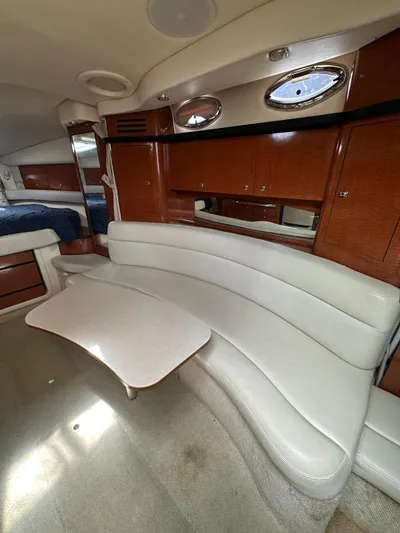  Yacht Photos Pics 2004 Sea Ray 340 Sundancer cabin with curved seating and wooden cabinetry.
