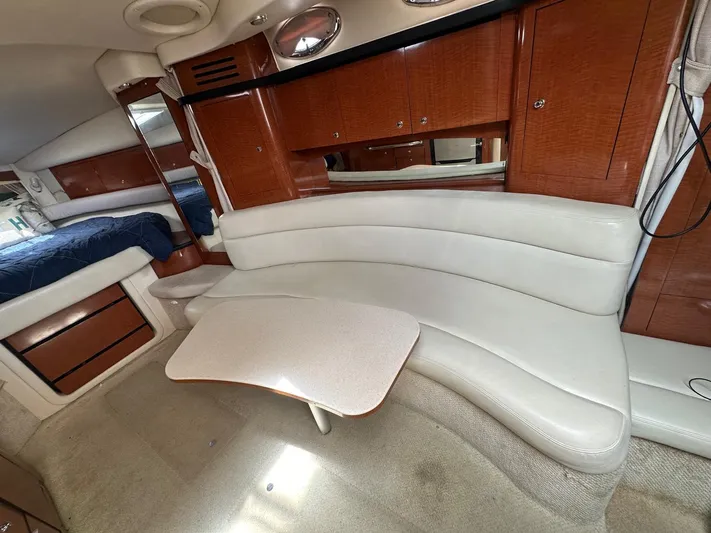  Yacht Photos Pics 2004 Sea Ray 340 Sundancer interior with curved seating and wooden cabinetry.