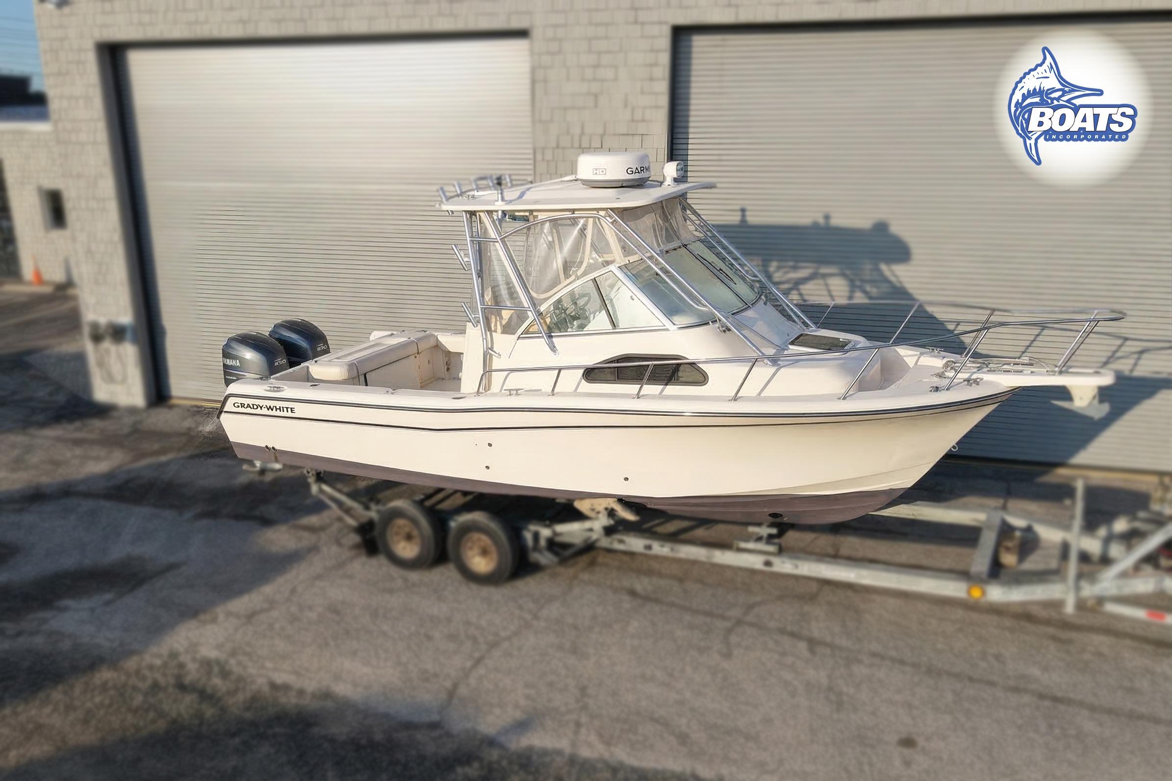 2008 Grady-White Sailfish 282 boat on trailer, parked outside industrial building.