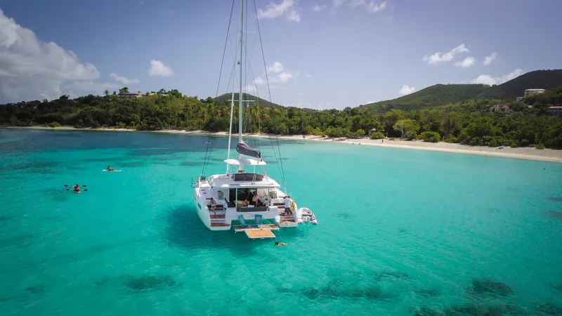 Karma Yacht Photos Pics Lagoon 50 catamaran anchored in turquoise waters near a tropical beach, 2020 model.