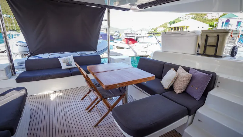 Karma Yacht Photos Pics Luxurious Lagoon 50 catamaran interior, 2020 model, featuring elegant seating and a wooden table.