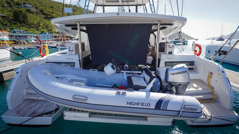 Karma Yacht Photos Pics Lagoon 50 catamaran with Highfield tender and Honda outboard motor, docked at marina.