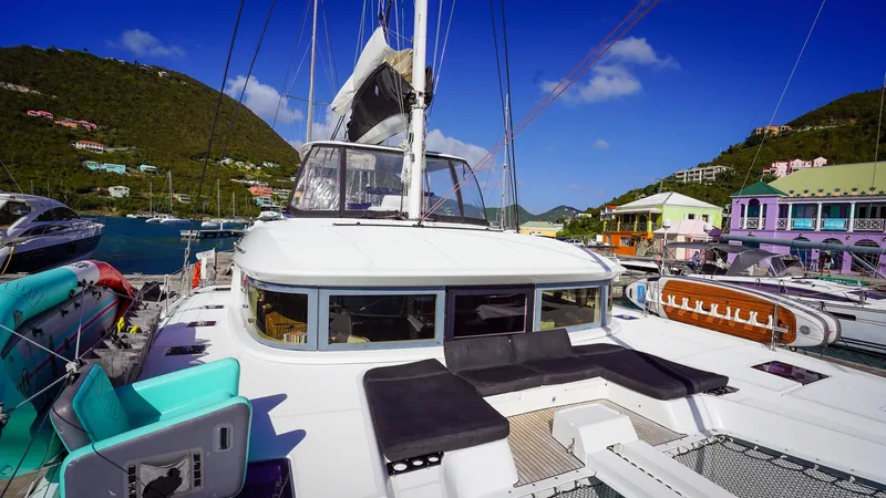 Karma Yacht Photos Pics Luxurious 2020 Lagoon 50 catamaran docked in a scenic marina with vibrant surroundings.