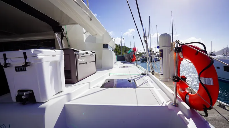 Karma Yacht Photos Pics 2020 Lagoon 50 catamaran deck with coolers and life preserver, docked at marina.