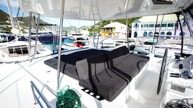 Karma Yacht Photos Pics Luxurious Lagoon 50 catamaran deck with seating, docked at a vibrant marina.
