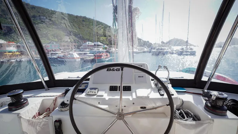 Karma Yacht Photos Pics Cockpit view of 2020 Lagoon 50 catamaran with steering wheel and marina backdrop.