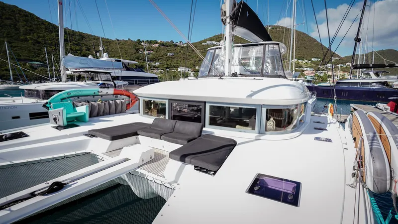 Karma Yacht Photos Pics 2020 Lagoon 50 catamaran docked in a scenic marina with lush hills in the background.