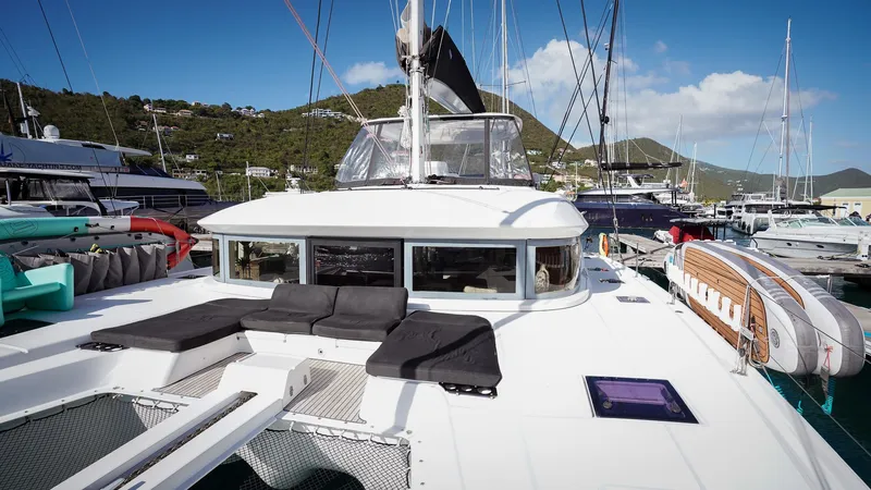 Karma Yacht Photos Pics 2020 Lagoon 50 catamaran docked in a marina, featuring spacious deck and scenic background.