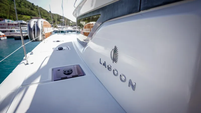 Karma Yacht Photos Pics 2020 Lagoon 50 yacht deck with logo, docked in a marina.
