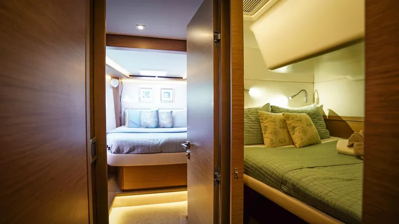 Karma Yacht Photos Pics Luxurious interior of 2020 Lagoon 50 yacht featuring cozy bedrooms with elegant bedding.