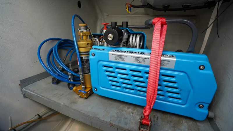 Karma Yacht Photos Pics Blue compressor unit in a Lagoon 50 yacht, 2020 model, with attached hoses and safety strap.