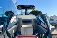 2025 Solaris Power 40F Open yacht with dual outboard engines, docked near a modern building.