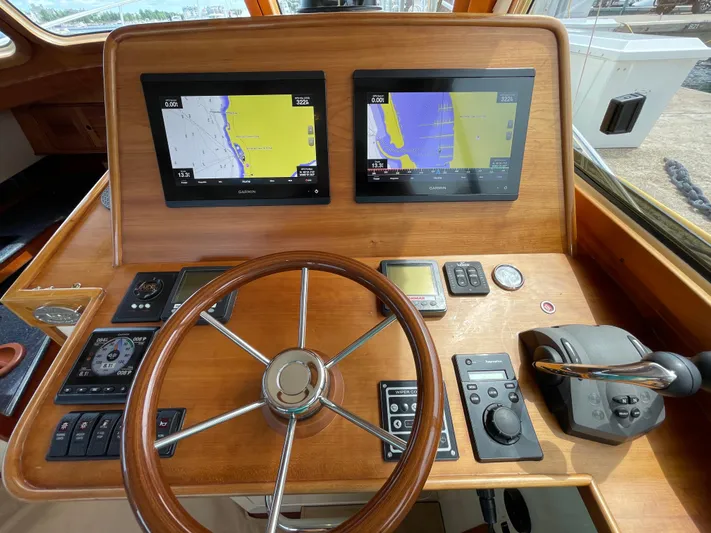 VII Yacht Photos Pics Helm of 2007 Hinckley Talaria 44 Flybridge with dual navigation screens and wooden steering wheel.