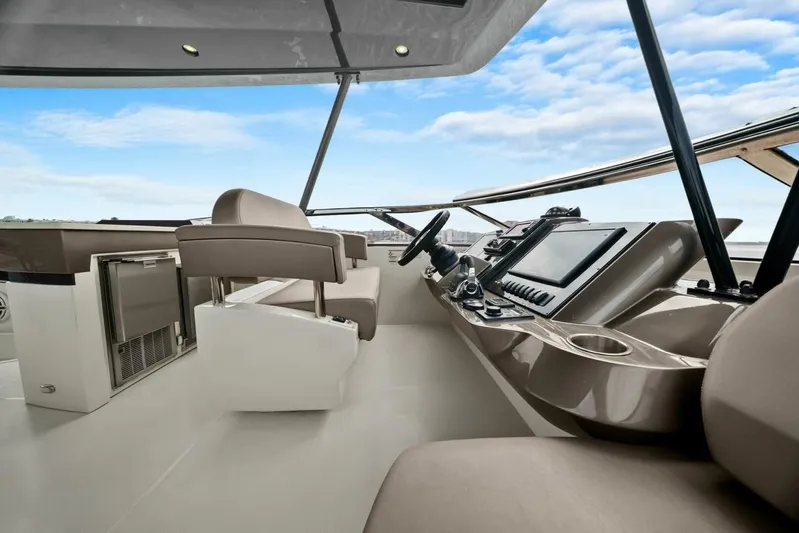 7th Heaven Yacht Photos Pics 2014 Marquis 630 Sport Yacht helm with modern controls and seating, under a clear blue sky.