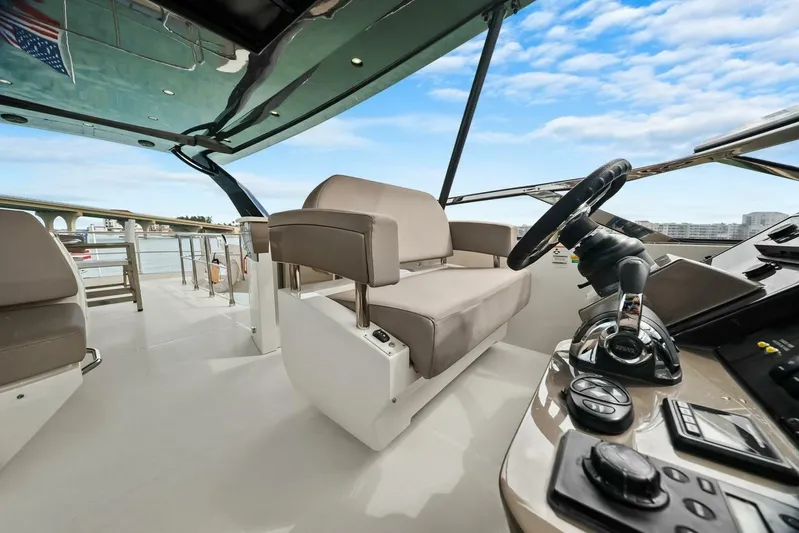 7th Heaven Yacht Photos Pics 2014 Marquis 630 Sport Yacht helm with modern controls and seating, under a clear blue sky.