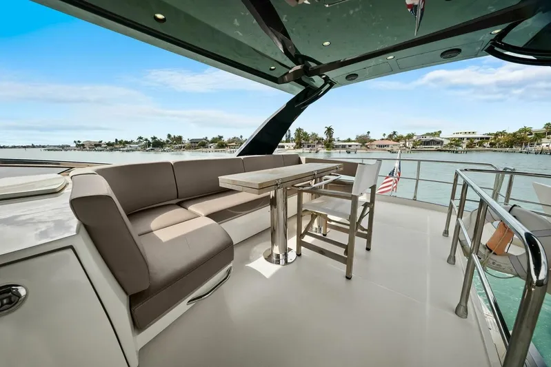 7th Heaven Yacht Photos Pics Luxurious 2014 Marquis 630 Sport Yacht deck with seating and table, overlooking serene waters.