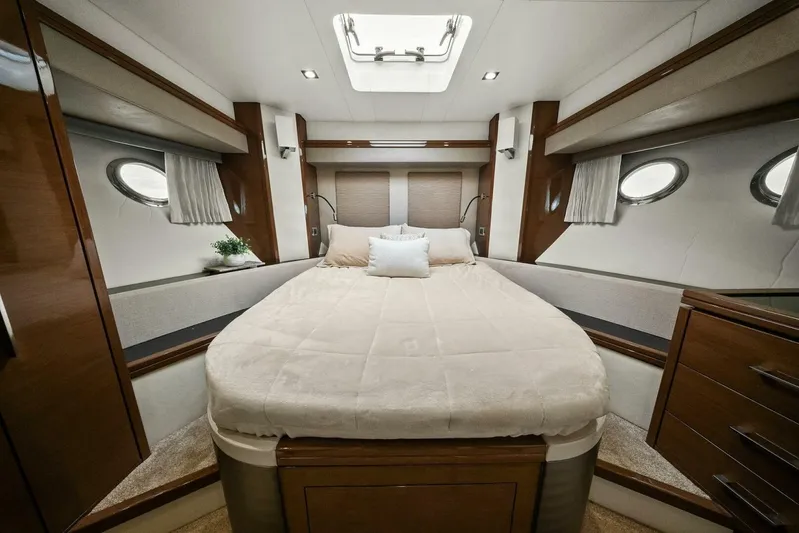 7th Heaven Yacht Photos Pics Luxurious bedroom interior of 2014 Marquis 630 Sport Yacht with elegant wood finishes.