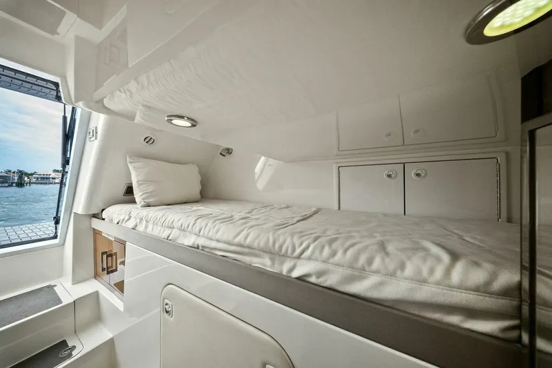 7th Heaven Yacht Photos Pics Luxurious cabin interior of 2014 Marquis 630 Sport Yacht with cozy bed and scenic window view.