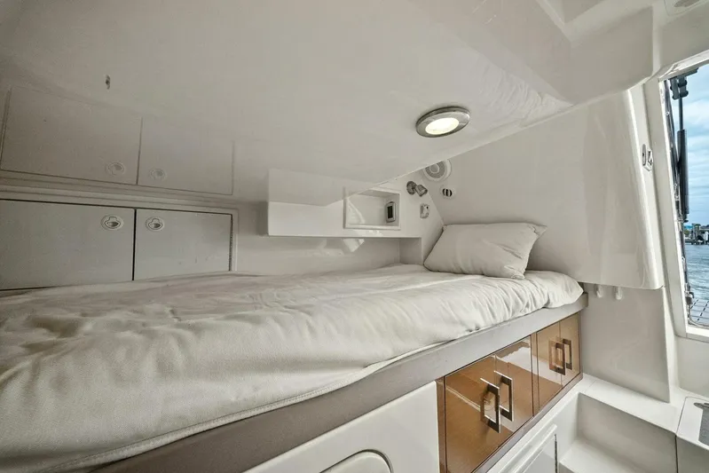 7th Heaven Yacht Photos Pics Cozy cabin interior of 2014 Marquis 630 Sport Yacht with bed and storage.