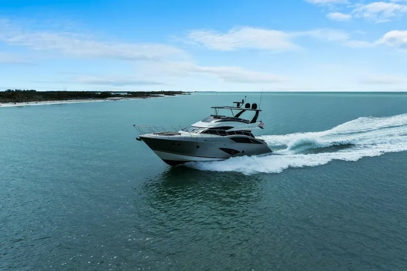 7th Heaven Yacht Photos Pics 2014 Marquis 630 Sport Yacht cruising on open water under a clear blue sky.