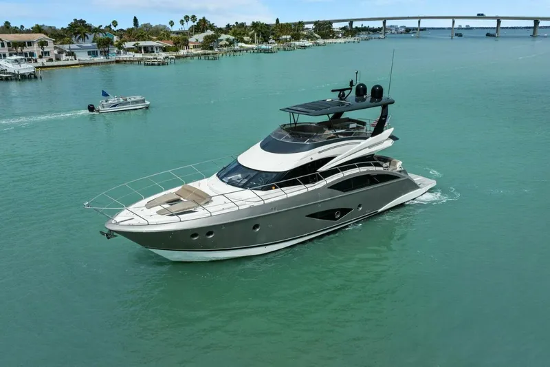 7th Heaven Yacht Photos Pics 2014 Marquis 630 Sport Yacht cruising in turquoise waters near coastal homes.