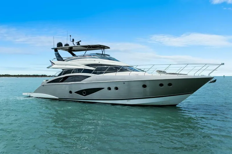 7th Heaven Yacht Photos Pics 2014 Marquis 630 Sport Yacht cruising on calm blue waters under a clear sky.