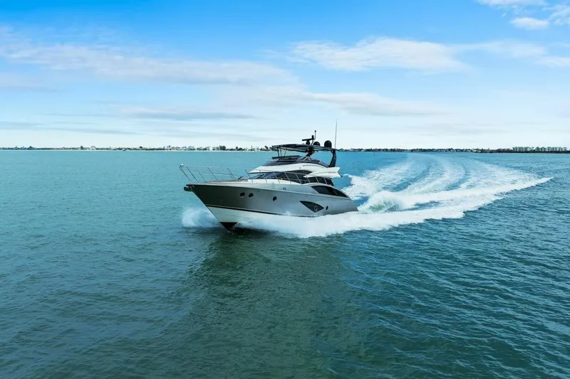 7th Heaven Yacht Photos Pics 2014 Marquis 630 Sport Yacht cruising on open water under a clear blue sky.