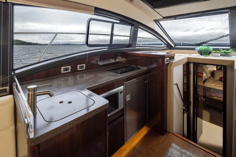 You Betcha Yacht Photos Pics Interior of 2016 Sea Ray 400 Sundancer yacht with modern kitchen and scenic windows.
