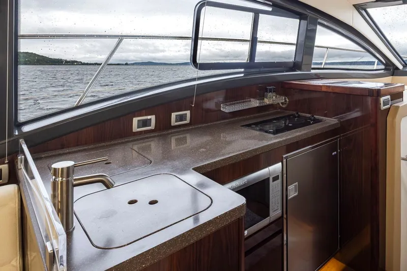 You Betcha Yacht Photos Pics Interior view of 2016 Sea Ray 400 Sundancer yacht kitchen with sleek design and ocean backdrop.