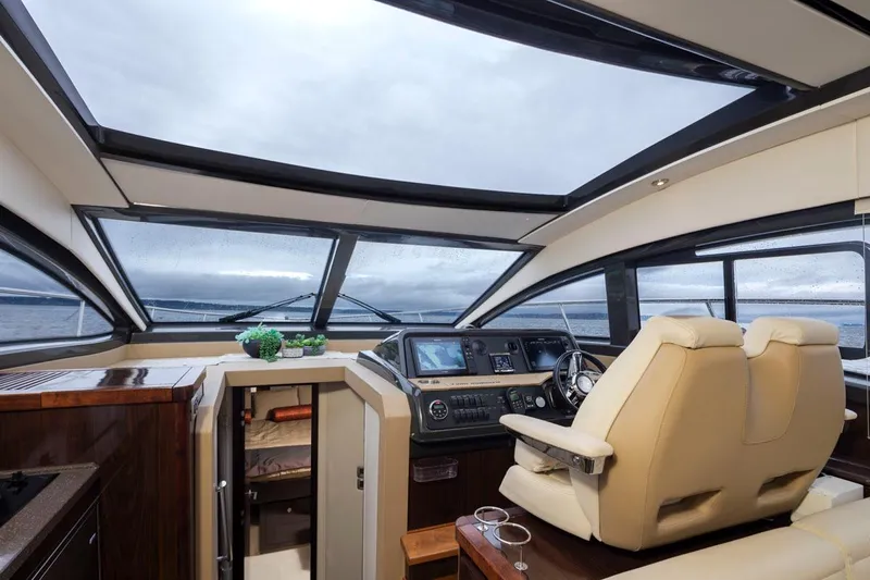 You Betcha Yacht Photos Pics Interior of 2016 Sea Ray 400 Sundancer yacht with modern helm and panoramic windows.