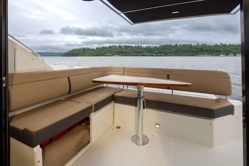 You Betcha Yacht Photos Pics 2016 Sea Ray 400 Sundancer boat interior with seating and table, overlooking a scenic lake.
