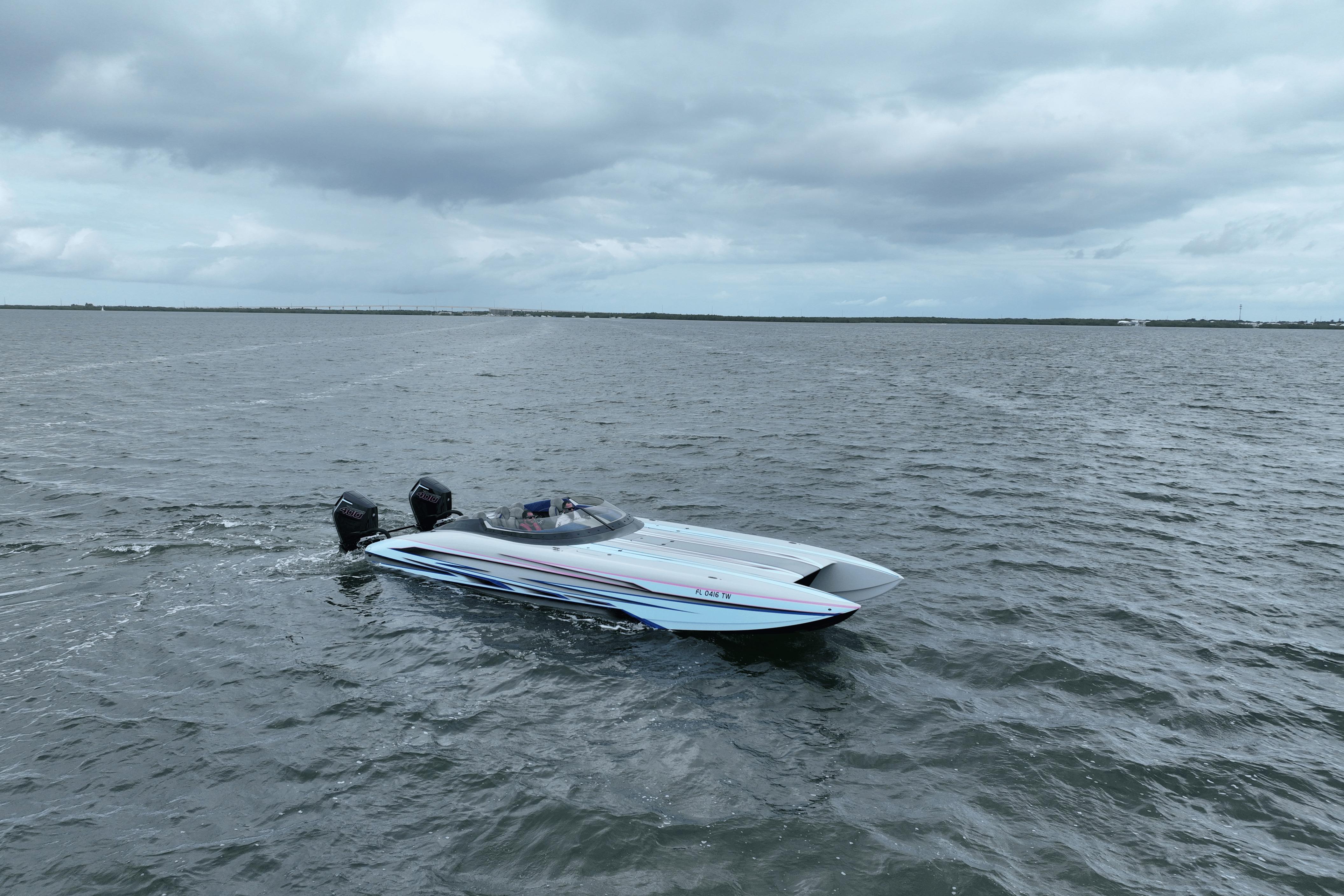 2024 Dug Wright 32 speedboat cruising on open water under cloudy skies.