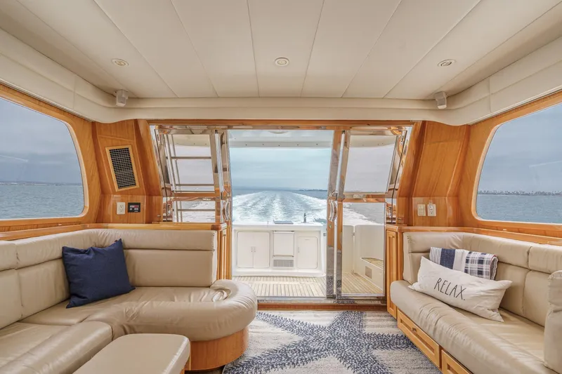 Sweet Seas Yacht Photos Pics Luxurious interior of 2001 McKinna 57 Pilothouse yacht with ocean view through glass doors.