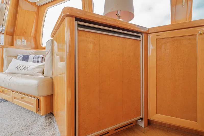 Sweet Seas Yacht Photos Pics Luxurious interior of 2001 McKinna 57 Pilothouse yacht with cozy seating and wooden cabinetry.