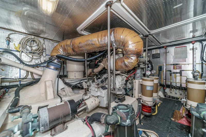 Sweet Seas Yacht Photos Pics Engine room of a 2001 McKinna 57 Pilothouse yacht, showcasing complex machinery.