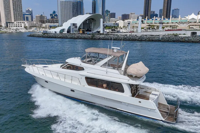 Sweet Seas Yacht Photos Pics 2001 McKinna 57 Pilothouse yacht cruising near urban waterfront skyline.