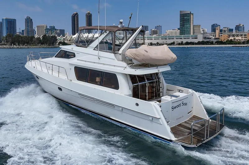 Sweet Seas Yacht Photos Pics 2001 McKinna 57 Pilothouse yacht cruising near city skyline.
