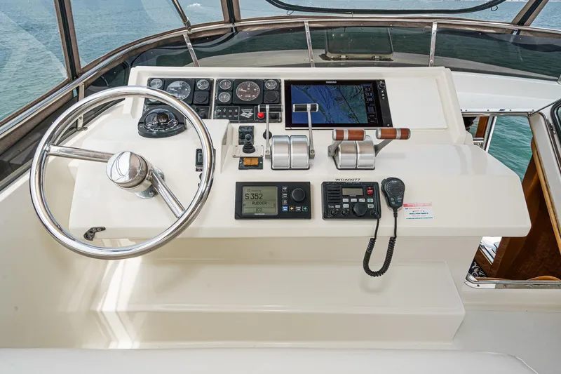 Sweet Seas Yacht Photos Pics 2001 McKinna 57 Pilothouse helm with steering wheel, navigation controls, and ocean view.