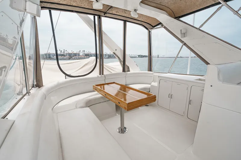 Sweet Seas Yacht Photos Pics 2001 McKinna 57 Pilothouse yacht interior with white seating and wooden table.