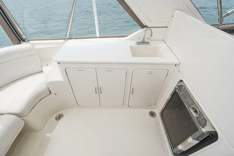 Sweet Seas Yacht Photos Pics 2001 McKinna 57 Pilothouse yacht interior with sink, storage cabinets, and seating.