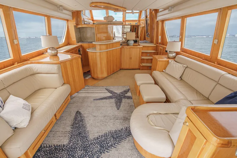 Sweet Seas Yacht Photos Pics Luxurious interior of 2001 McKinna 57 Pilothouse yacht with elegant wood finishes and plush seating.