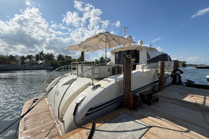  Yacht Photos Pics Luxury Leopard 27m yacht docked, 2005 model, with sunshade and scenic waterfront view.