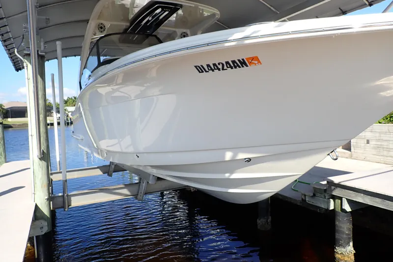  Yacht Photos Pics 2021 Scout 277 Dorado boat on lift, docked by waterfront.