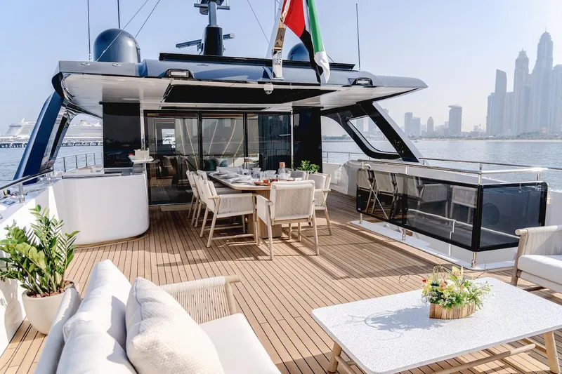  Yacht Photos Pics Luxurious Majesty 100 Terrace yacht deck with elegant seating, dining area, and city skyline view.
