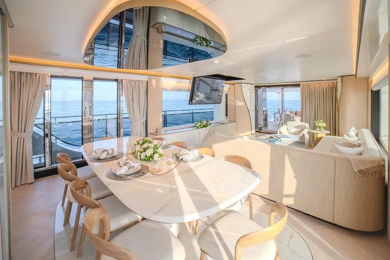  Yacht Photos Pics Luxurious interior of 2025 Majesty 100 Terrace yacht with elegant dining area and ocean views.