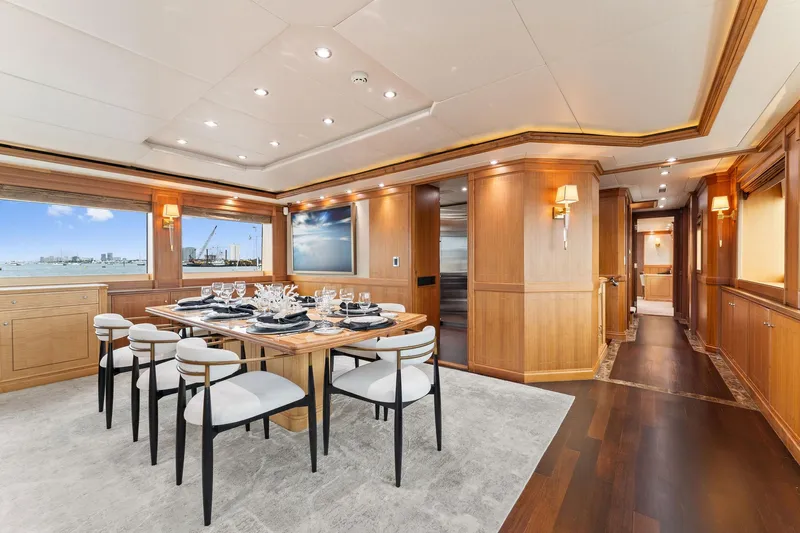 Invictus Yacht Photos Pics Luxurious dining area on 2006 Palmer Johnson motor yacht with elegant wood paneling and ocean view.