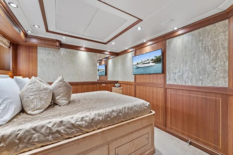 Invictus Yacht Photos Pics Luxurious bedroom interior of 2006 Palmer Johnson 123 Motor Yacht with elegant wood paneling.