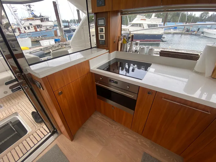 Sea Sea V Yacht Photos Pics Modern kitchen in 2020 Sunseeker Manhattan 52 yacht, featuring sleek wood cabinetry and waterfront view.