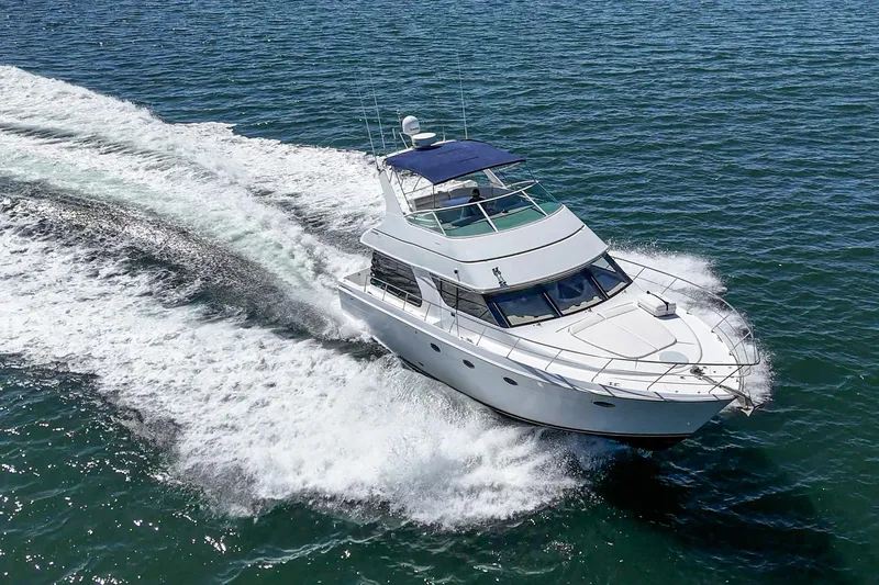 Kathy's Dream Yacht Photos Pics 2000 Carver 450 Voyager Pilothouse cruising on open water, creating a dynamic wake.