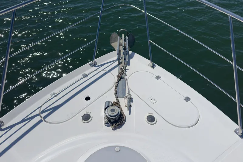 Kathy's Dream Yacht Photos Pics Bow of 2000 Carver 450 Voyager Pilothouse with anchor and railing over water.